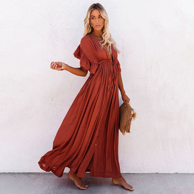 a woman in a red dress standing on a sidewalk 