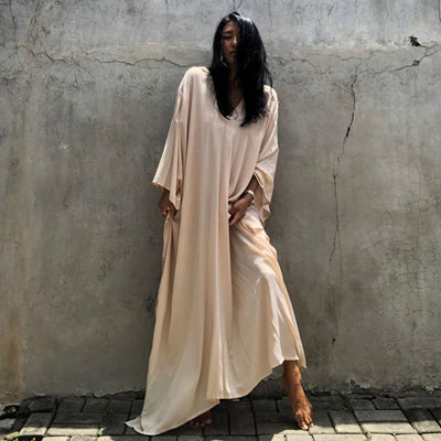 a woman in a white dress standing on a sidewalk 