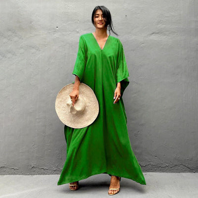 a woman in a green dress holding a plate of food 