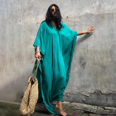 a woman in a green dress holding a cell phone 