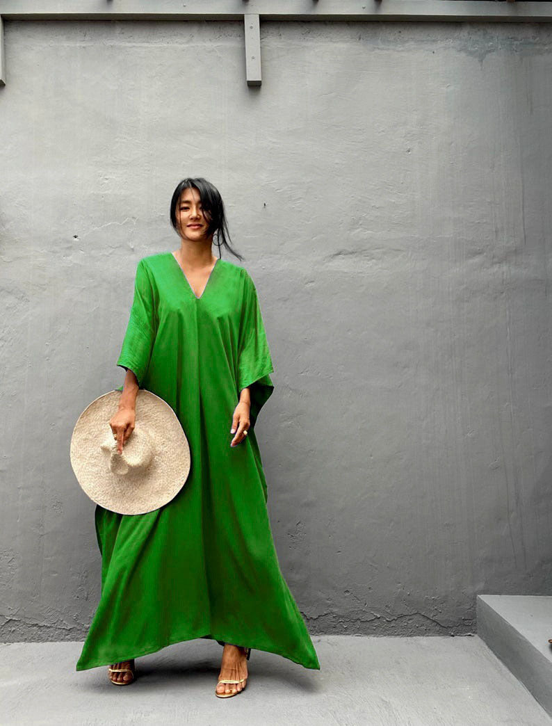 a woman in a green shirt holding a plate of food 