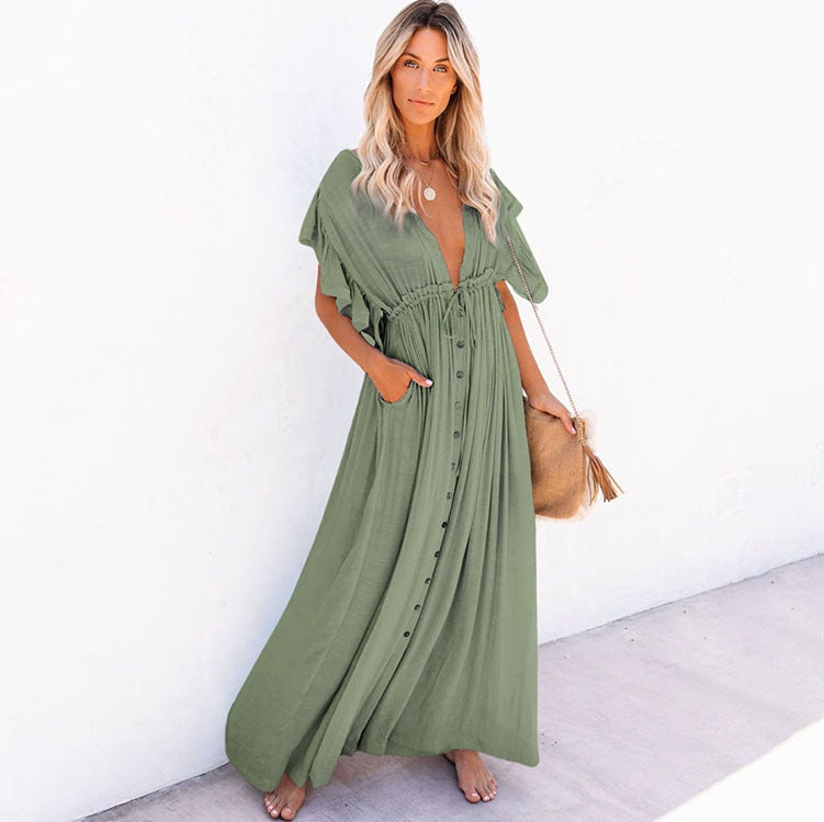 a woman in a green dress standing on a sidewalk 