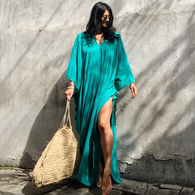 a woman in a green outfit holding a surfboard 